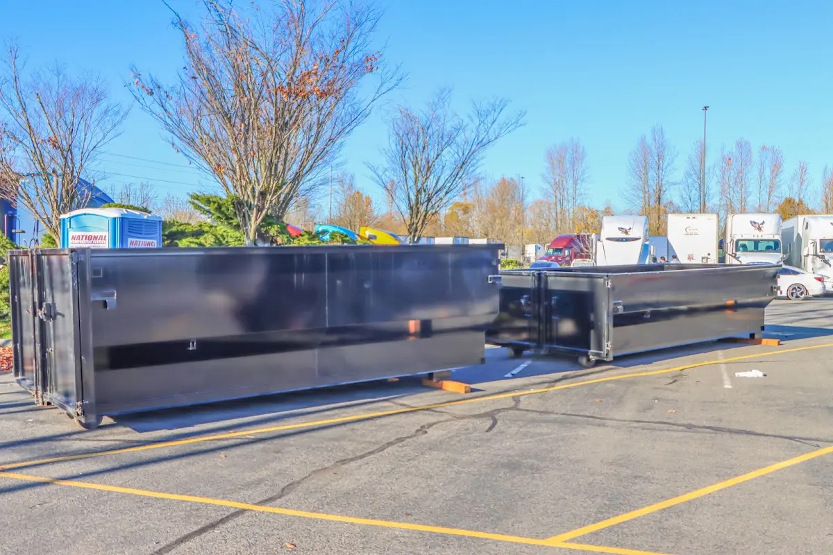 Professional dumpster rental service with roll-off container on residential driveway in Earl